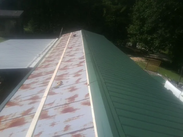 Old rusted panels beside newly installed green metal roofing — Wind Damage Roof Repair by Roofing Brothers in Tinley Park
