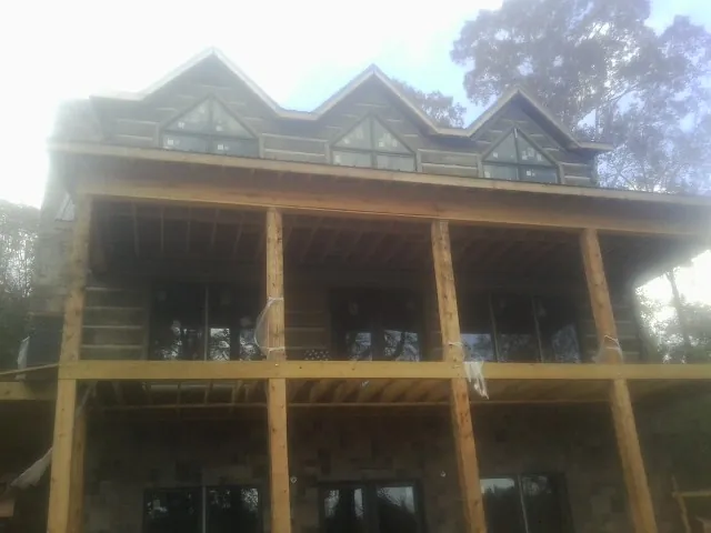 Dormers and porch framing on a large log home under construction — Roof Coating work by our crew in Tinley Park